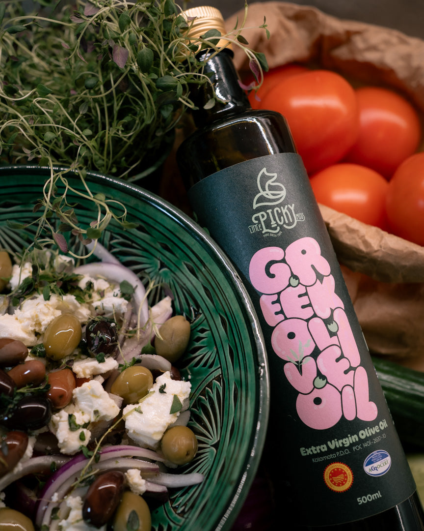 Flaska Greek Oil bredvid tomater, fetaost och grekisk sallad